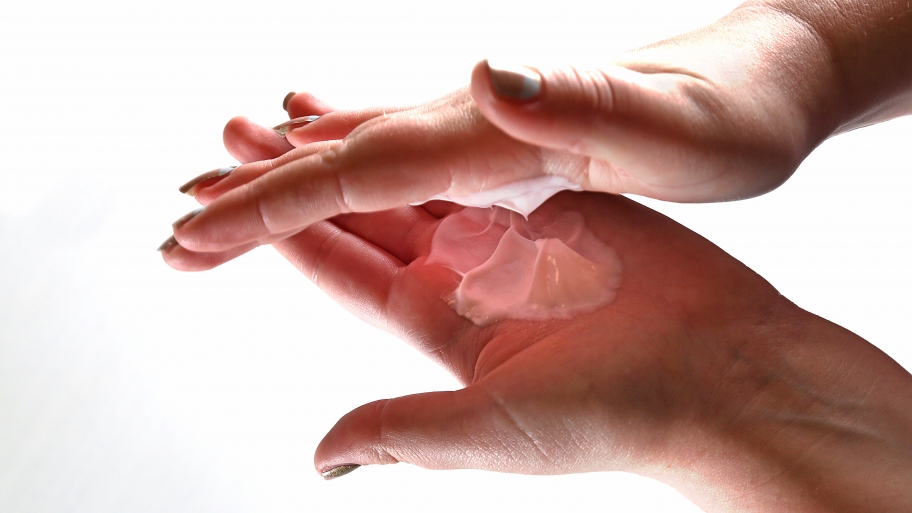 woman's hands rubbing lotion in